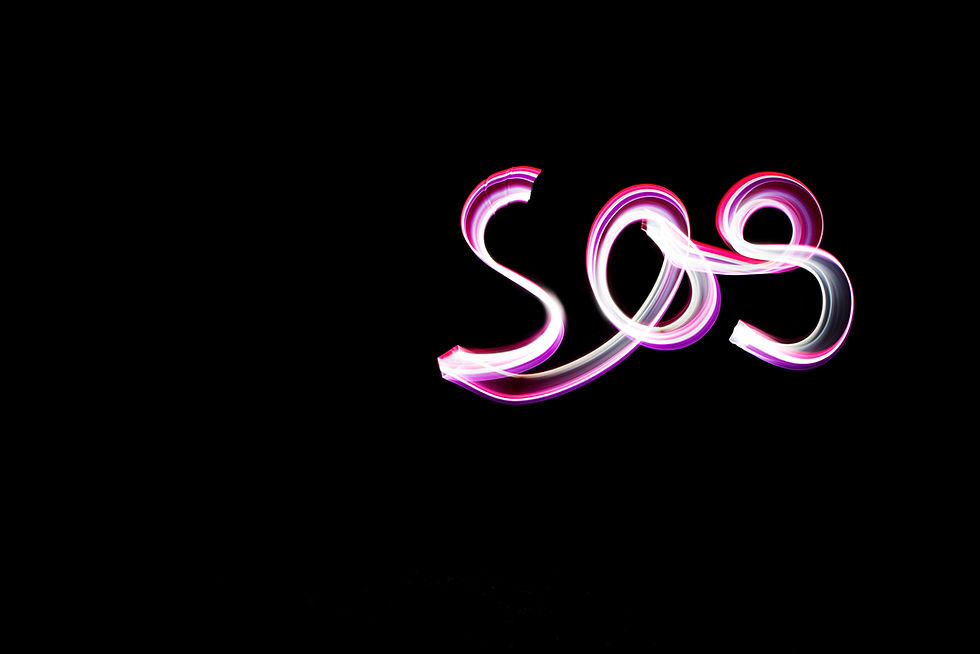 handwritten word SOS, light painting experiment with bulb exposure, at night. black backgr