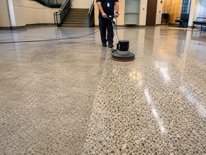 Professional technician restoring a dull terrazzo floor using commercial polishing equipment