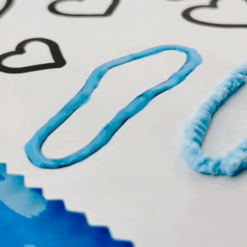 Puff paint being puffed on a valentine's day coloring page. Bright, creative, playful mood.