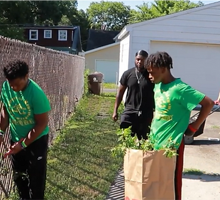 Teens picking up grass clippings after mowing the lawn, contributing to community upkeep and developing a strong work ethic.