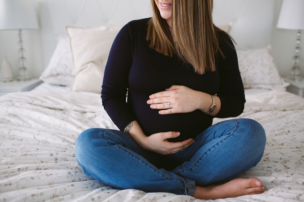 pregnant women sitting on bed at home