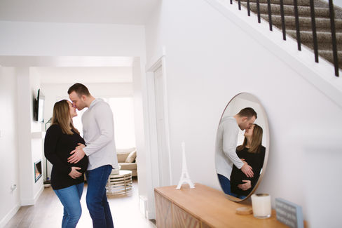 Maternity couple in-home reflection in mirror