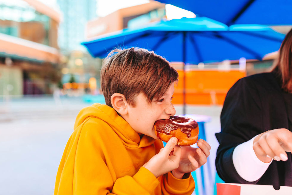 Boy eating chocolate doughnut