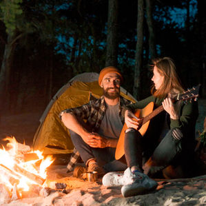 Koppel aan het kampvuur met gitaar