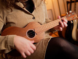 Vrouw speelt een G-akkoord op ukelele.