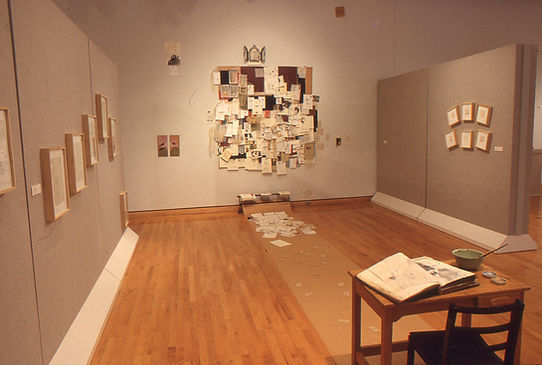 A mixed media studio art installation titled Objects of Devotion from an MFA thesis exhibition, displaying intricate textures and layered surfaces in a gallery setting