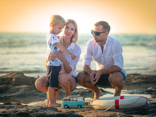 צילומי משפחה בטבע, הורים וילדים יושבים יחד בחוף הים