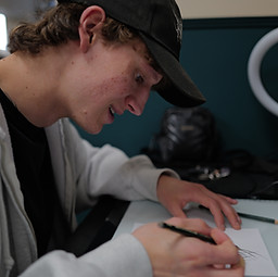 Pelle, tattoo artist at Bona Fide Tattoo in Heerlen city centre, drawing a design in the shop.