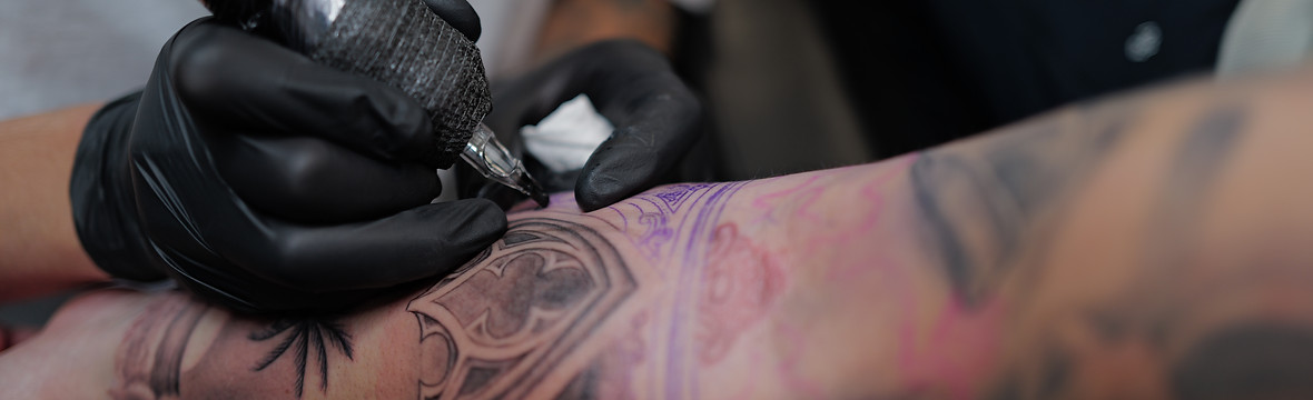 Close-up of a tattoo in progress at Bona Fide Tattoo in Heerlen, featuring a heavenly gate and palm tree design