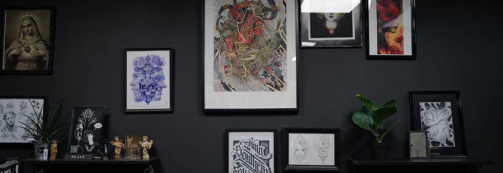 Interior of Bona Fide Tattoo shop and Gallery in Heerlen with black wall and colorful art display.