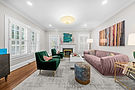 Modern living room with green velvet chairs and pink sofa