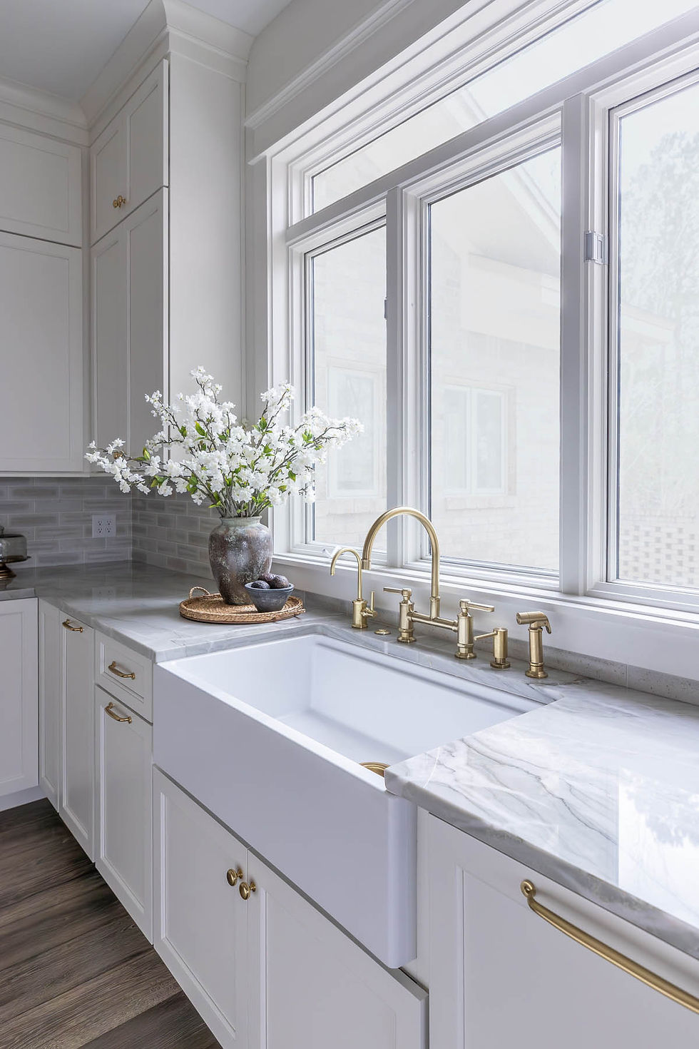 White kitchen with farmhouse sink and gold faucet