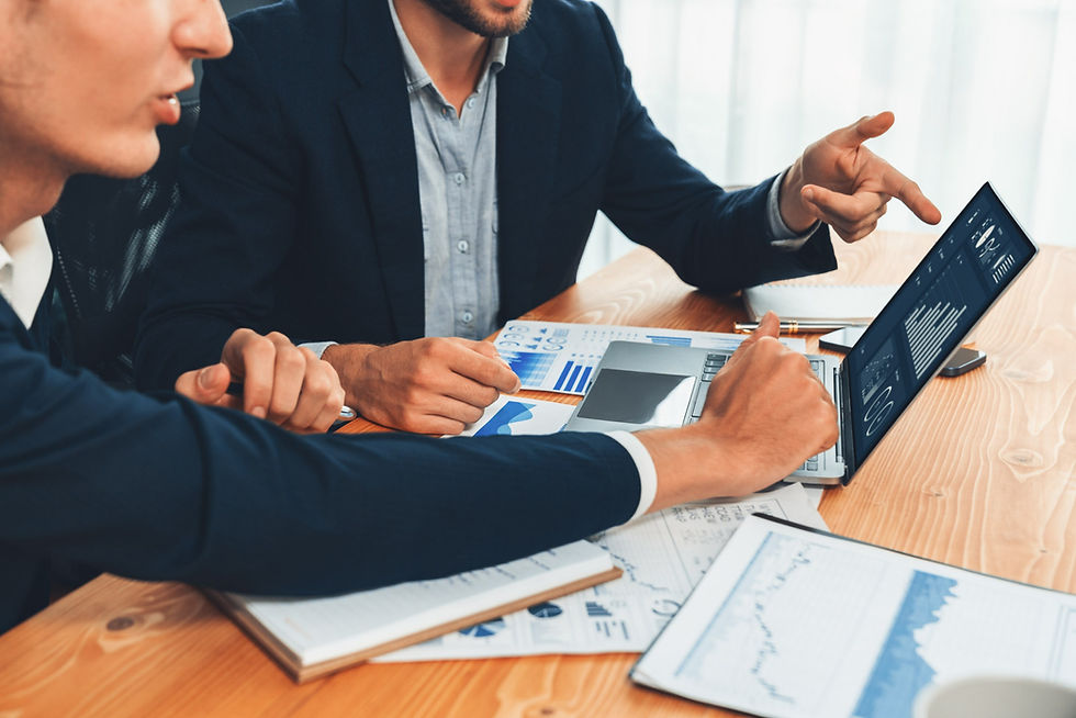 Businessmen analyzing charts on a laptop