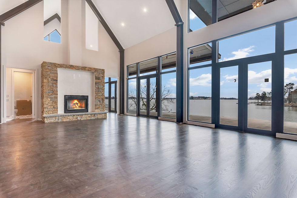 Modern living room with stone fireplace and lake view windows