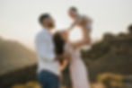 Parents lifting a baby up with a beautiful mountain background, family portrait.