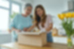 surprised-senior-woman-her-adult-daughter-unpacking-box-while-standing-domestic-kitchen.jp