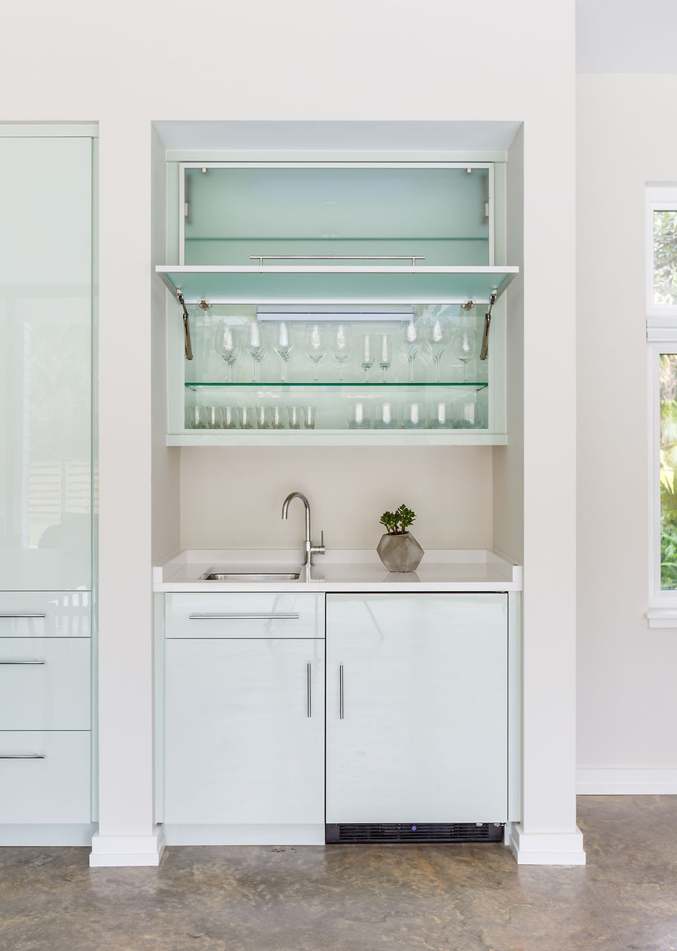 Modern built-in wet bar with sink and glassware