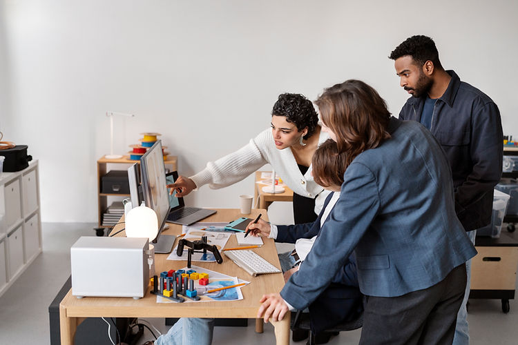 Team reviewing data on a computer monitor while collaborating in the office