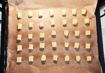 35 Stück Plätzchen auf einem mit Backpapier ausgelegten Backblech.