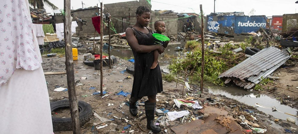 Cecilia Borges e seu filho Fernandinho Armindo caminham por um assentamento informal destruído em Beira, Moçambique. Foto: UNICEF/de Wet