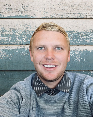 A smiling man in a sweater and tie, identified as Kyler Herdt, golf instructor at APEXGOLF Instruction.