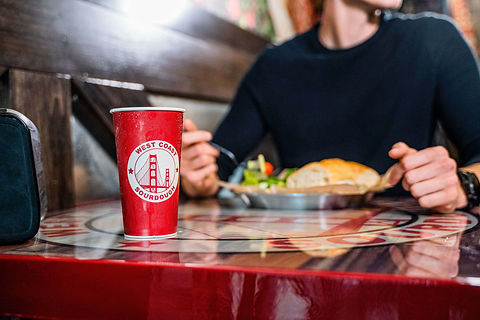 soda cup with man eating west coast sourdoughsalad