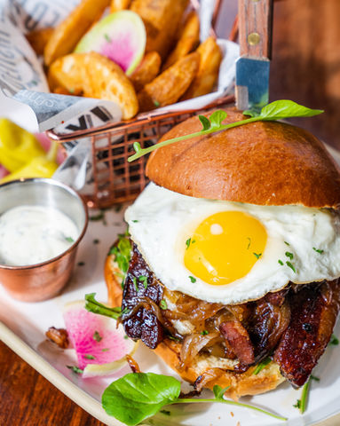 Fried egg bacon burger with potato wedges