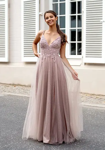 A woman in a pink embroidered evening gown standing 
