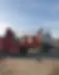 flatbed truck unloading a red skip