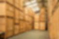 A spacious warehouse filled with tall wooden crates