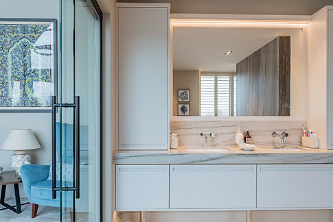 A spacious bathroom featuring a large mirror above white cabinets