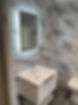 A bathroom with marble walls and a white sink
