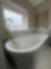 A white freestanding bathtub and marble wall tiles