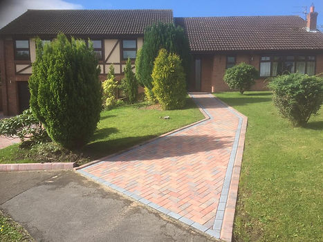 A garden with a block paved driveway