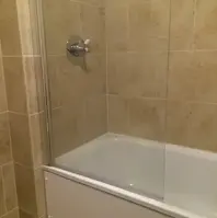 a picture of a bath with a glass panel 
