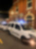 Two "Tommy's Taxis" vehicles are parked in front of a building