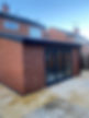 A red brick extension with large sliding glass doors
