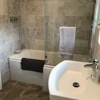 a newly renovated bathroom with a bath and sink included 