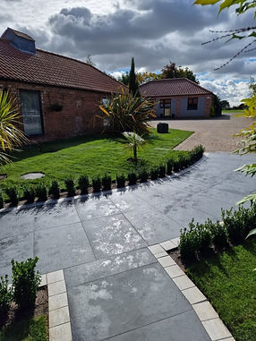 Curved stone pathway bordered by small bushes