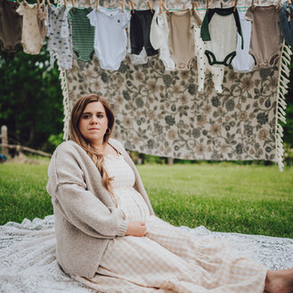 expecting parents hanging baby clothes during storytelling maternity photography session in Southern Indiana