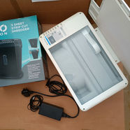 White strip-cut shredder with open lid, 5 sheet capacity, ON logo, and power adapter