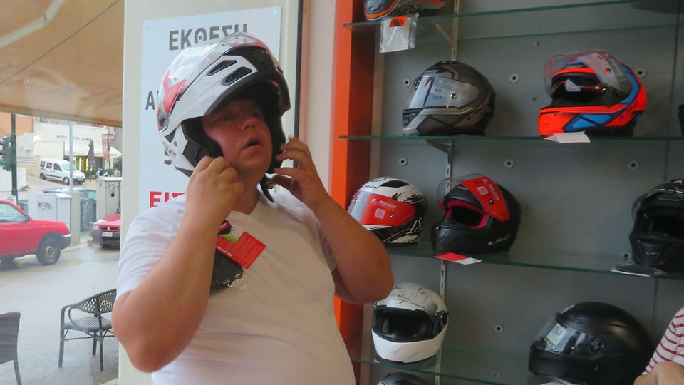 man with t-shirt trying on a motorcycle helmet