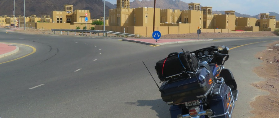 black harley davidson motorcycle parked on the road in a sandy area