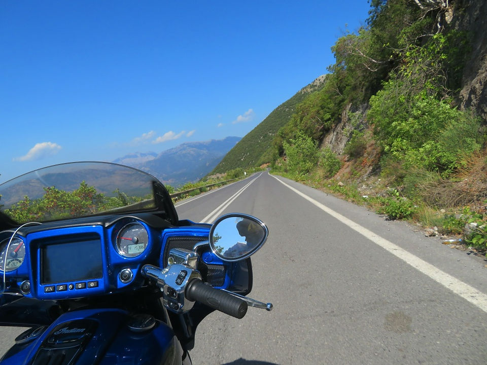 blue motorcycle riding a mountain road in greece