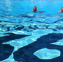 Large Route 66 sign at the bottom of a pool, man swimming