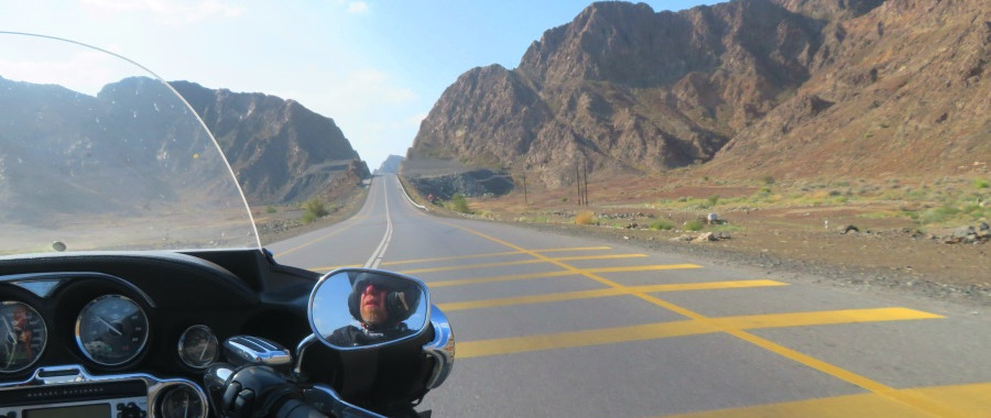 biker on motorcycle riding alone on the road, his reflection in the mirror