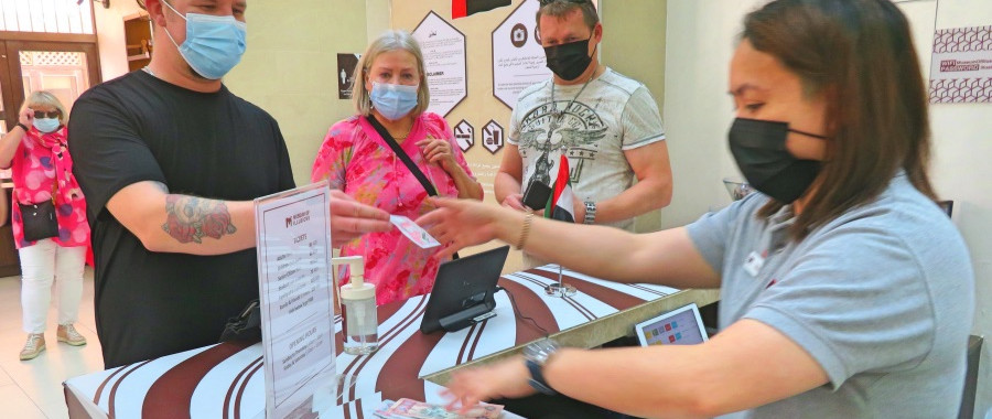 Man in black tshirt and women tourists at the change office in Dubai