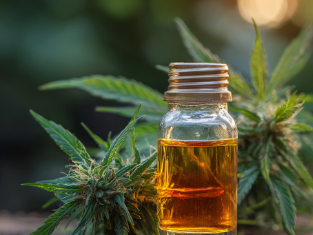 Flacon d'huile de CBD posé devant une feuille de chanvre