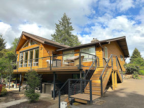 Restored cedar log cabin stained with Benjamin Moore WoodLuxe Semi Solid Natural Cedartone in Newberg Oregon