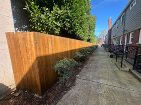 Restored HOA perimeter fencing in downtown Portland finished with Behr semi-transparent waterproofing stain and sealer after graffiti removal.
